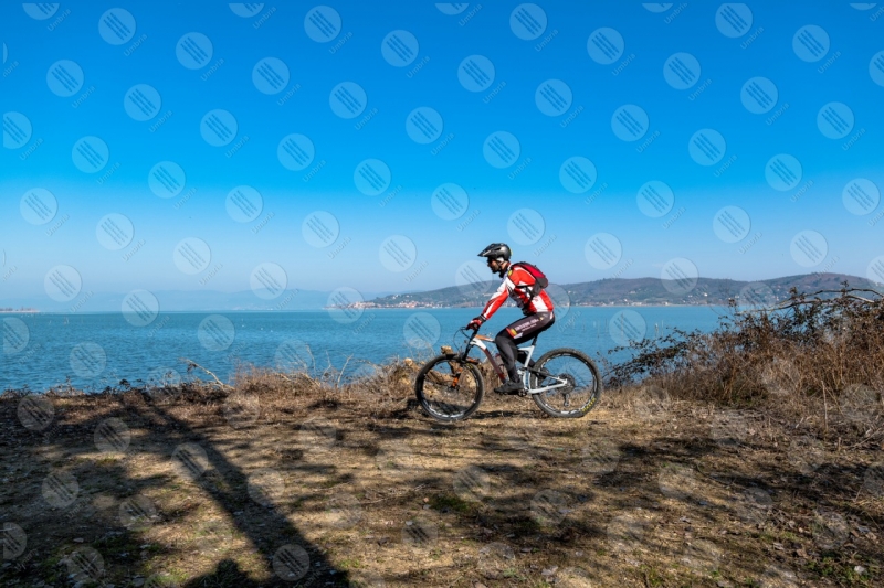 Lago Trasimento bici ciclista San Feliciano sponda acqua cielo cielo sereno uomo panorama vista paesaggio  Trasimeno