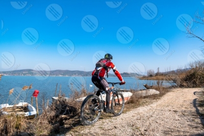 trasimeno Trasimeno lake bike bicycle cyclist shore boats water pathway sky clear sky panorama view landscape man swans
