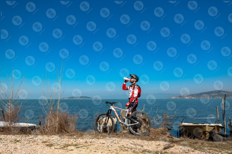 Lago Trasimeno bici ciclista San Feliciano Isola Polvese sponda barche acqua cielo cielo sereno panorama vista paesaggio uomo  Trasimeno