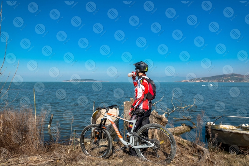 Lago Trasimeno bici ciclista San Feliciano Isola Polvese sponda barche acqua cielo cielo sereno panorama vista paesaggio uomo  Trasimeno