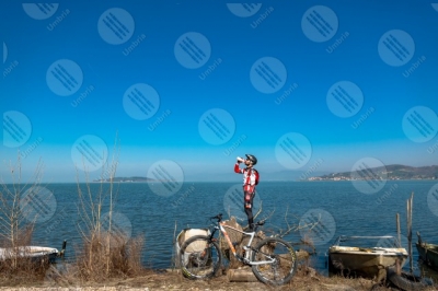 trasimeno Lago Trasimeno bici ciclista San Feliciano Isola Polvese sponda acqua barche cielo cielo sereno panorama vista paesaggio uomo