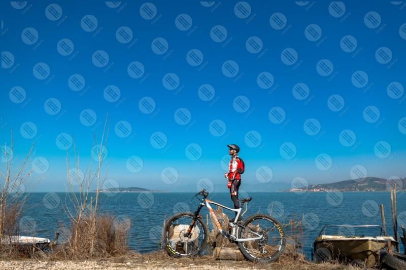 Lago Trasimeno bici ciclista San Feliciano Isola Polvese sponda acqua barche cielo cielo sereno panorama vista paesaggio uomo  Trasimeno