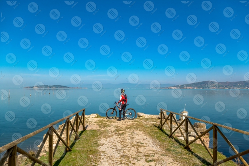 Lago Trasimeno bici ciclista San Feliciano Isola Polvese sponda sentiero acqua cielo cielo sereno panorama vista paesaggio uomo  Trasimeno